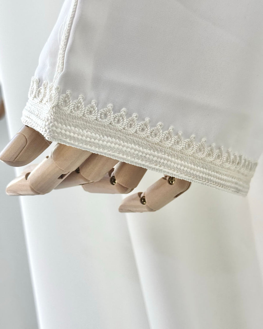 mannequin portant abaya femme matiere legere de couleur blanche avec un travail finition faite main vue manche