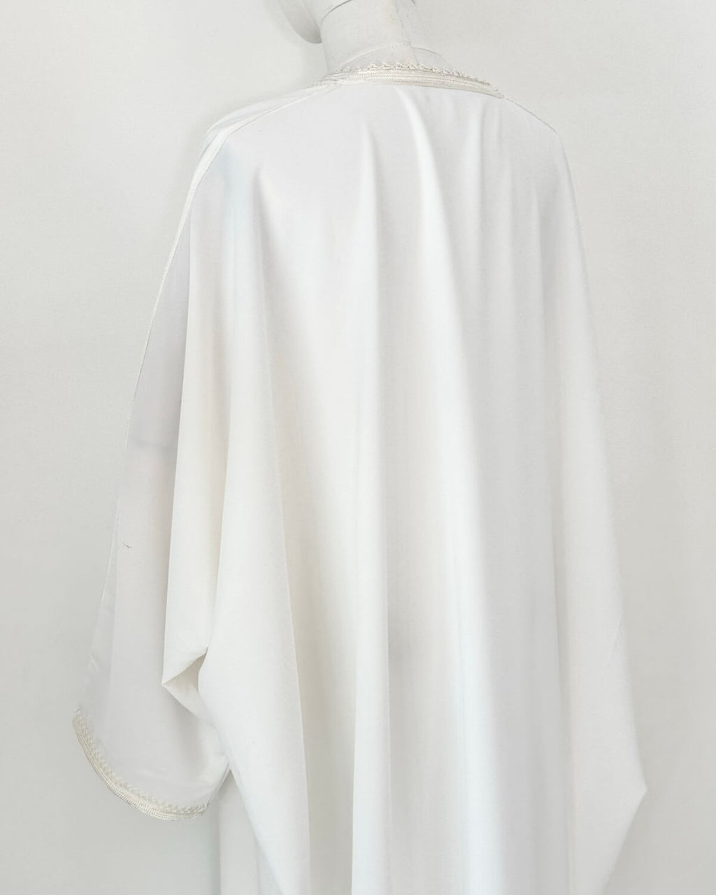 mannequin portant abaya femme matiere legere de couleur blanche avec un travail finition faite main vue dos