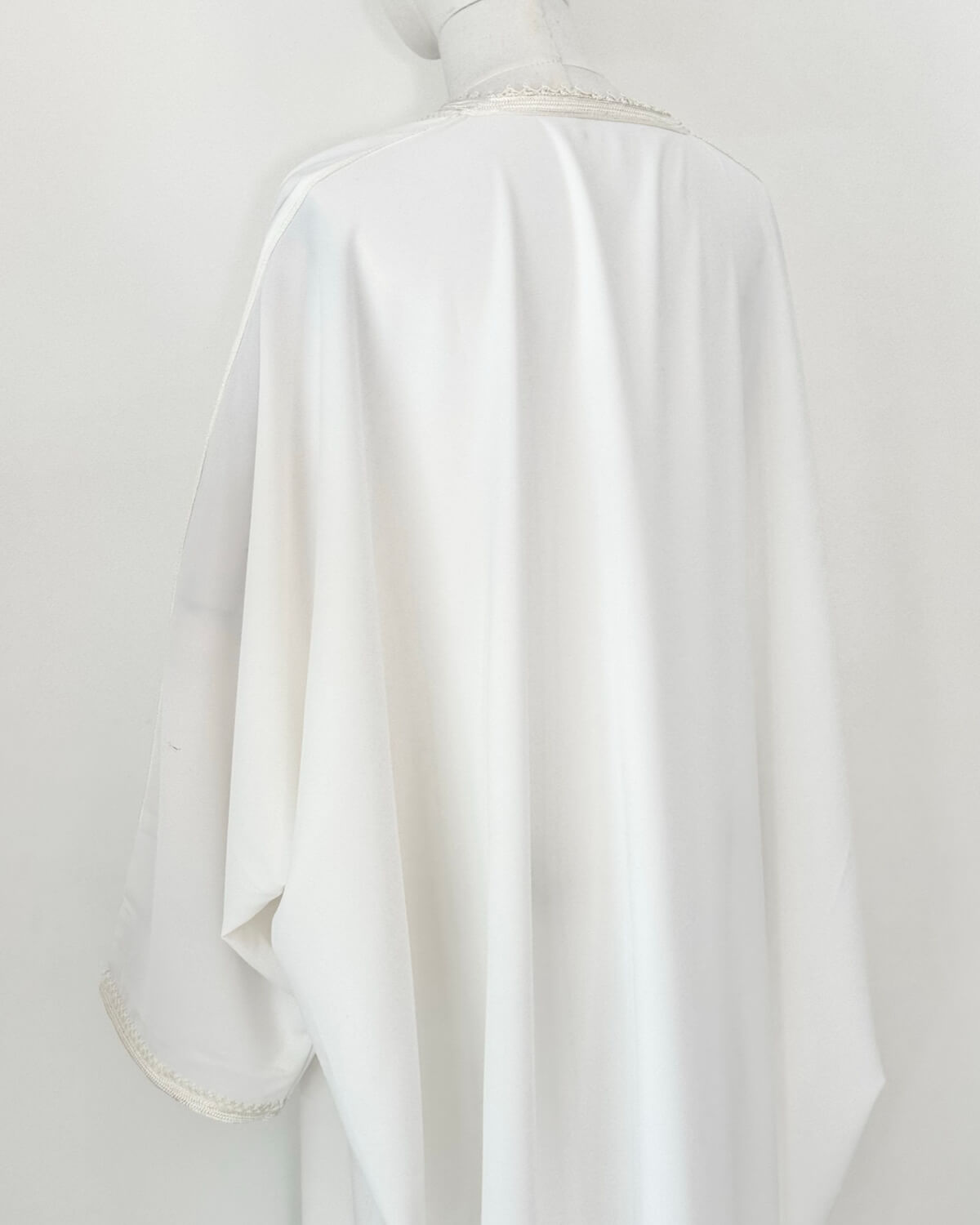 mannequin portant abaya femme matiere legere de couleur blanche avec un travail finition faite main vue dos