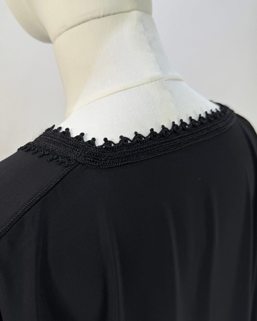 mannequin portant abaya femme matiere legere de couleur noire avec un travail finition faite main vue details-col