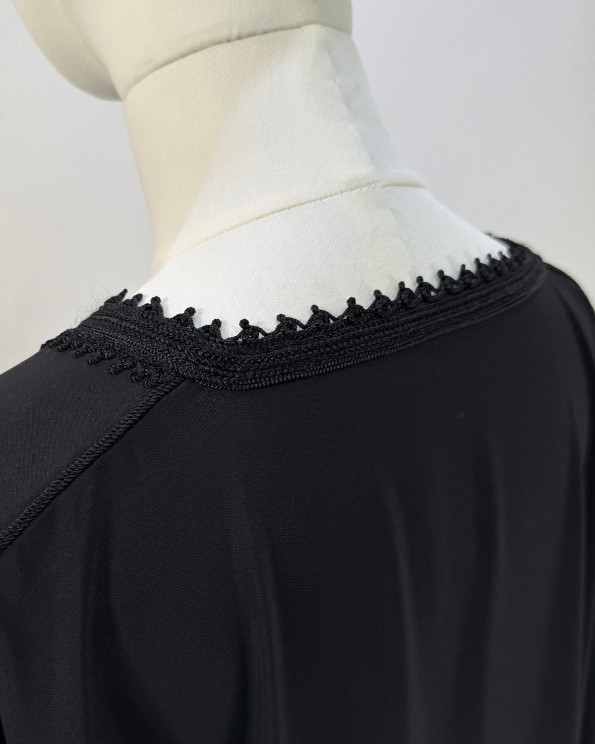 mannequin portant abaya femme matiere legere de couleur noire avec un travail finition faite main vue details-col