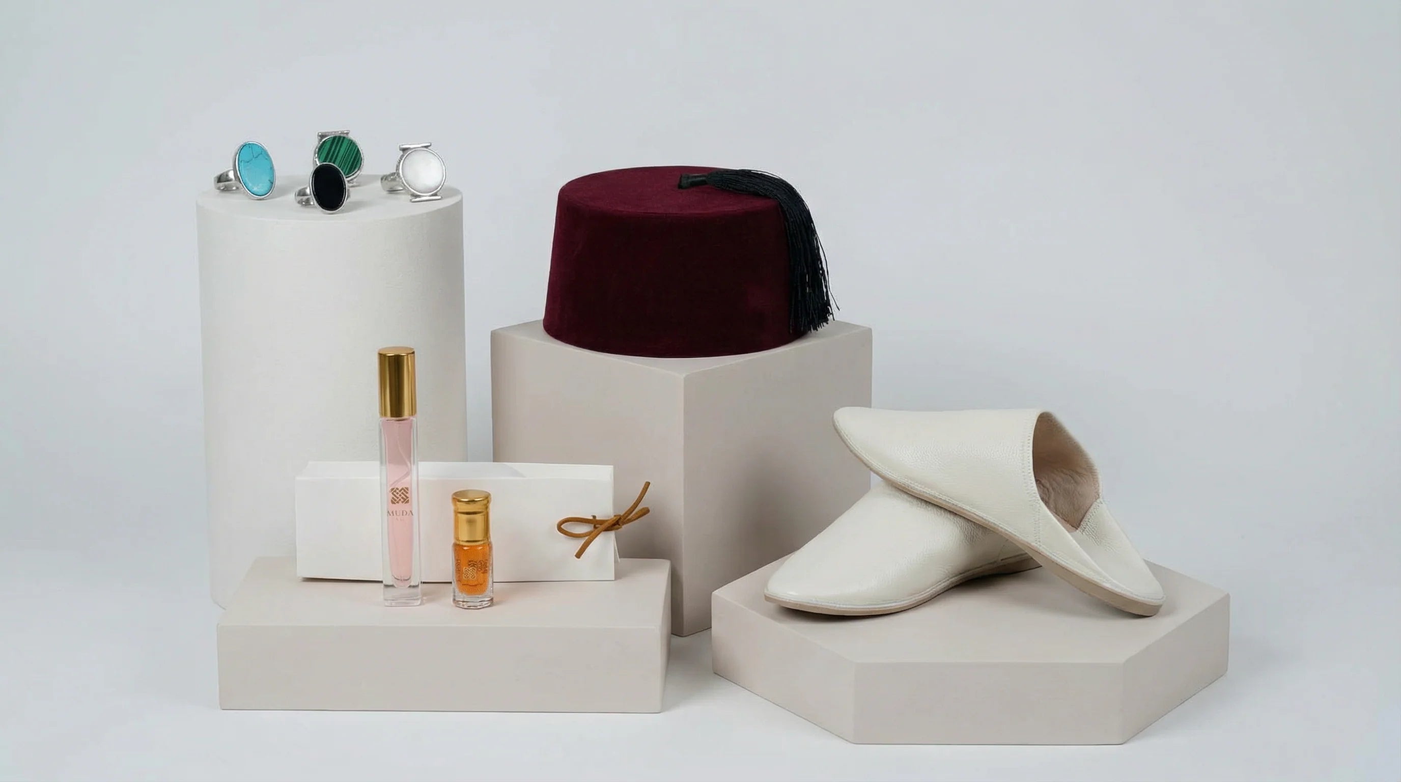 photo studio d'un terbouch, de babouches, bagues et parfums présentés sur des petits podiums