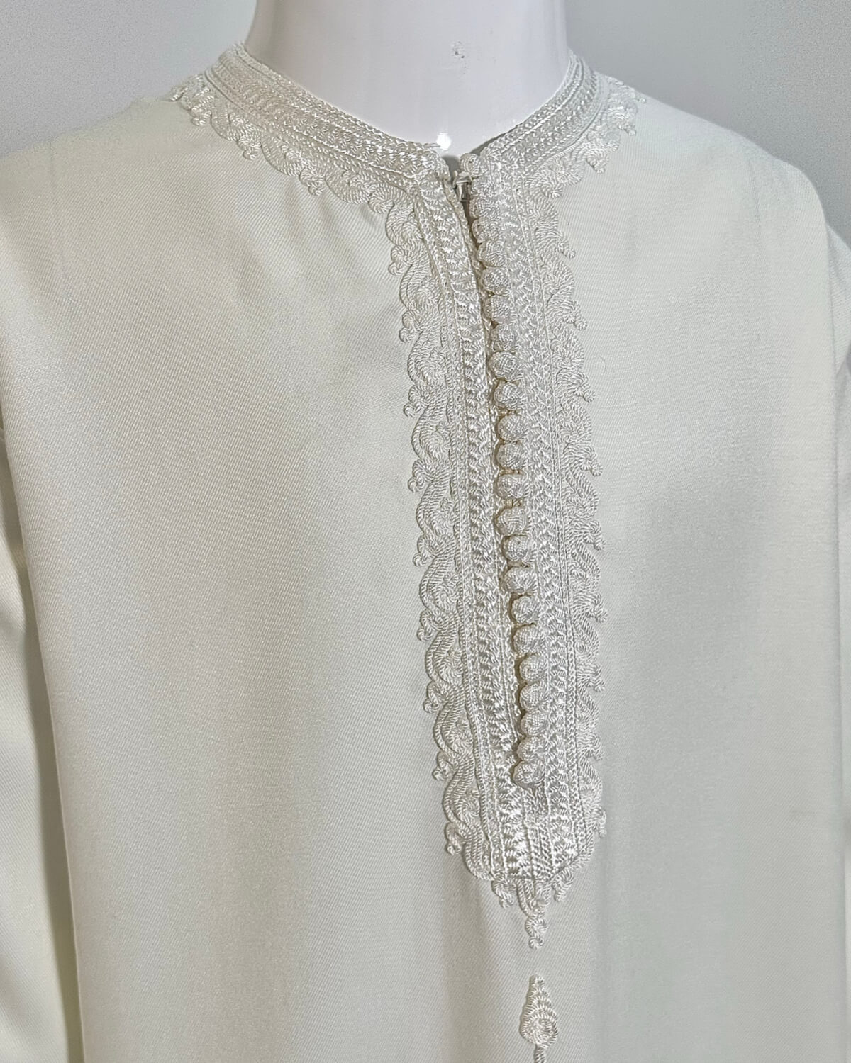 mannequin portant caftan enfant matiere gabardine de couleur blanc avec un travail finition faite main vue face-rapprochee