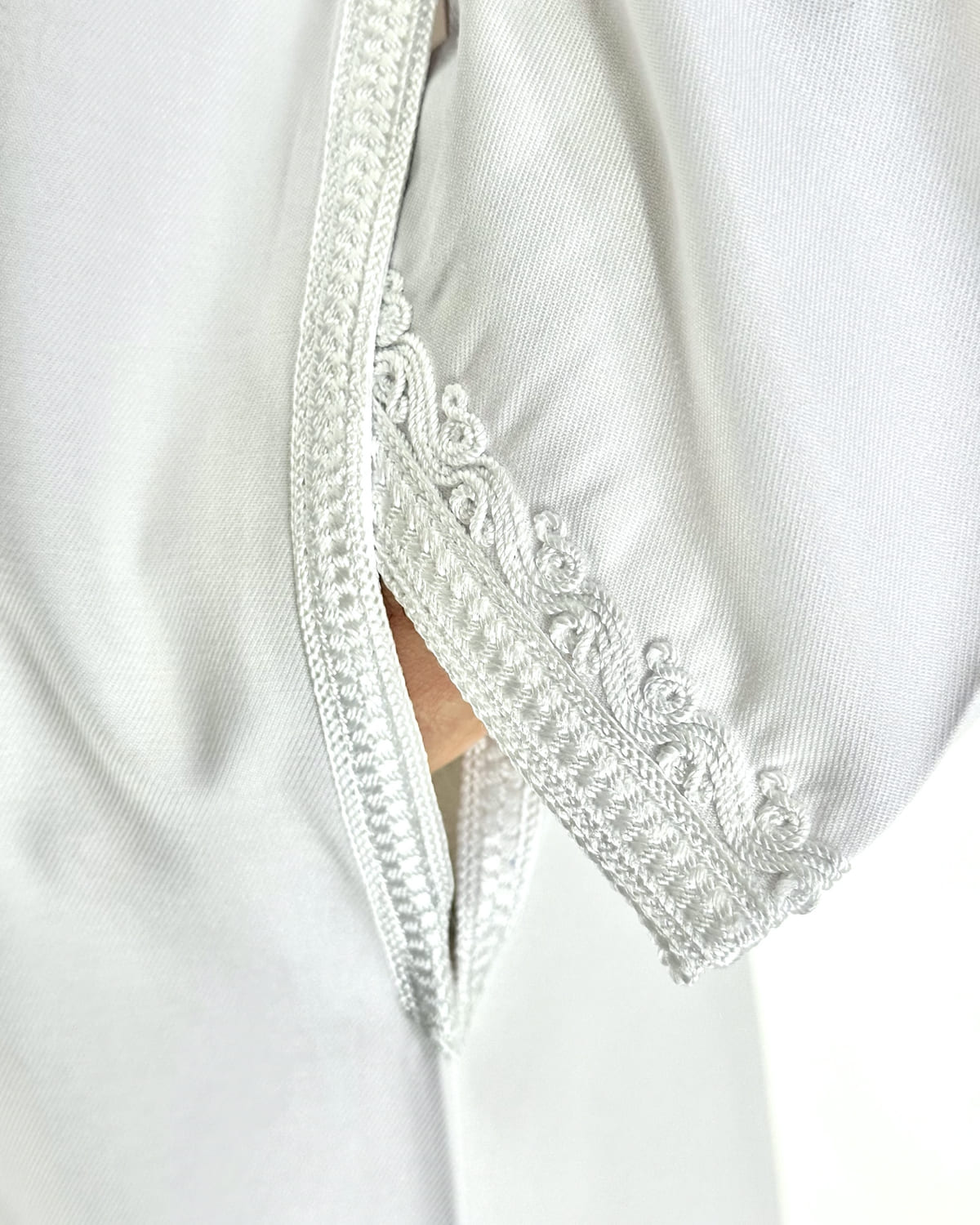mannequin portant caftan homme matiere gabardine de couleur blanc-pur avec un travail finition faite main vue manche