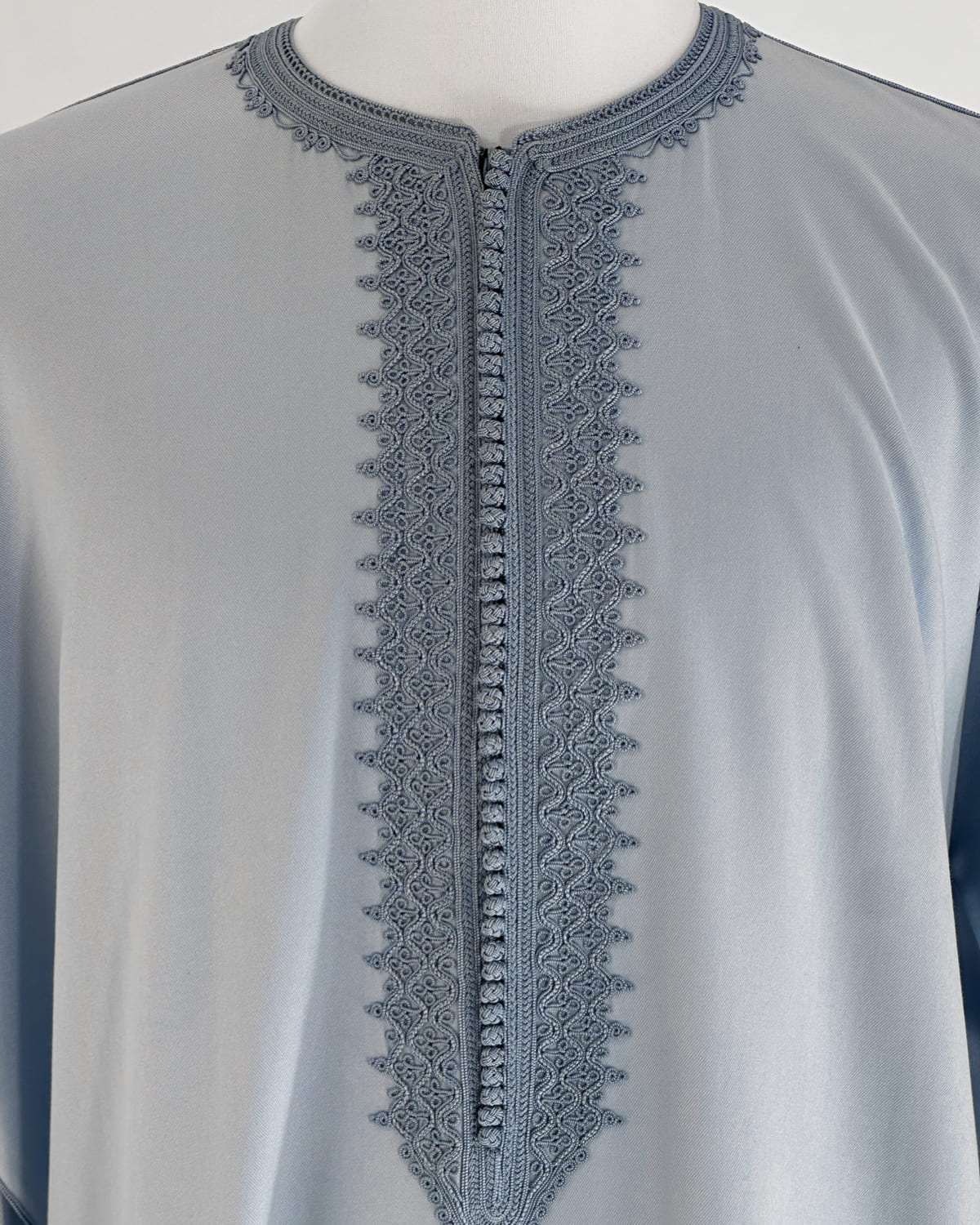 mannequin portant caftan homme matiere gabardine de couleur bleu-ciel avec un travail entierement fait main vue motifs