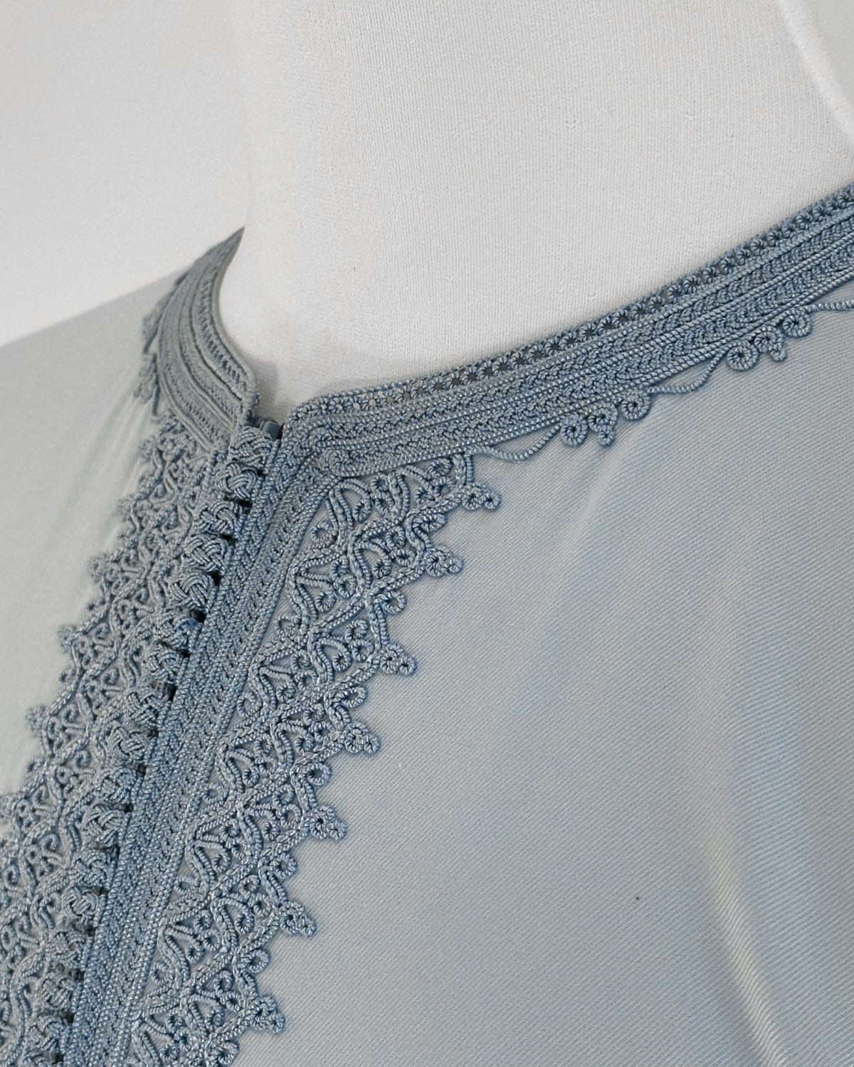 mannequin portant caftan homme matiere gabardine de couleur bleu-ciel avec un travail entierement fait main vue details-rapproches