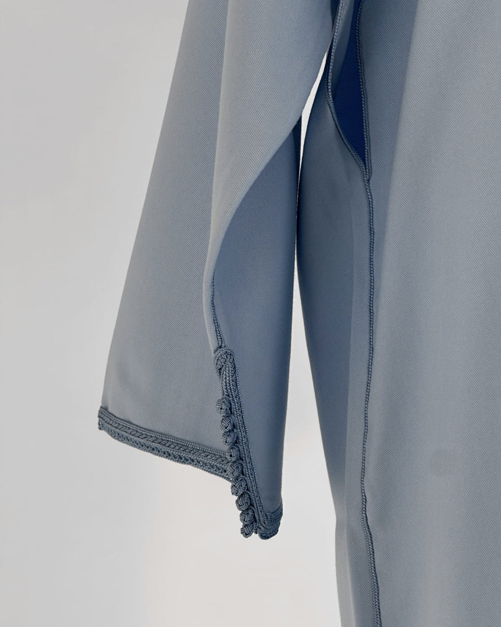 mannequin portant caftan homme matiere gabardine de couleur bleu-ciel avec un travail entierement fait main vue manche