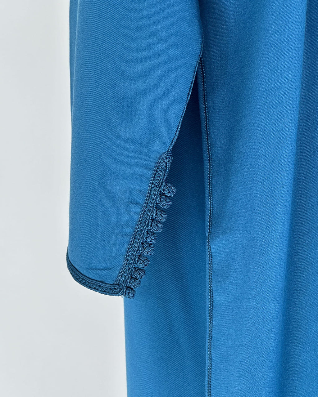 mannequin portant caftan homme matiere gabardine de couleur bleu avec un travail entierement fait main vue manche