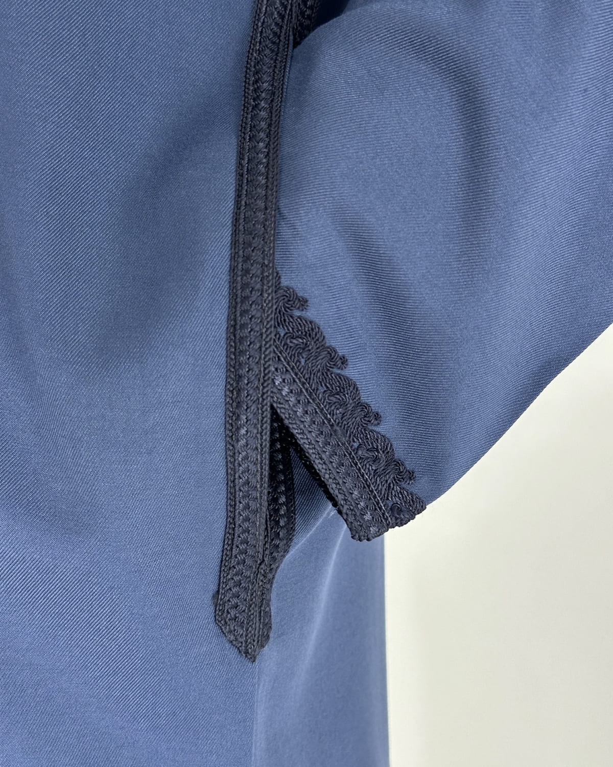 mannequin portant caftan homme matiere gabardine de couleur bleu avec un travail finition faite main vue manche