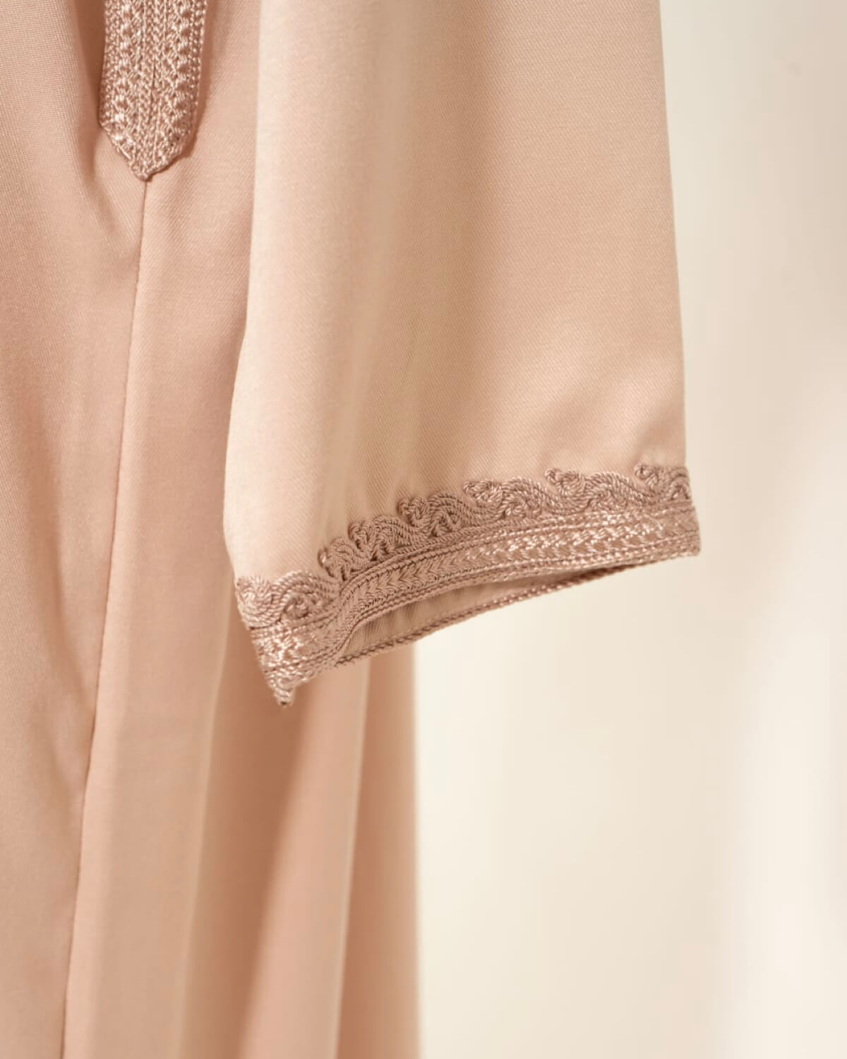 mannequin portant caftan homme matiere gabardine de couleur rose-poudre avec un travail finition faite main vue manche