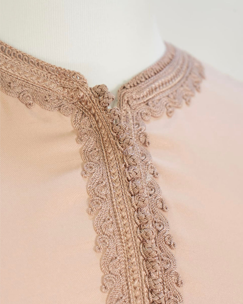 mannequin portant caftan homme matiere gabardine de couleur rose-poudre avec un travail finition faite main vue motifs