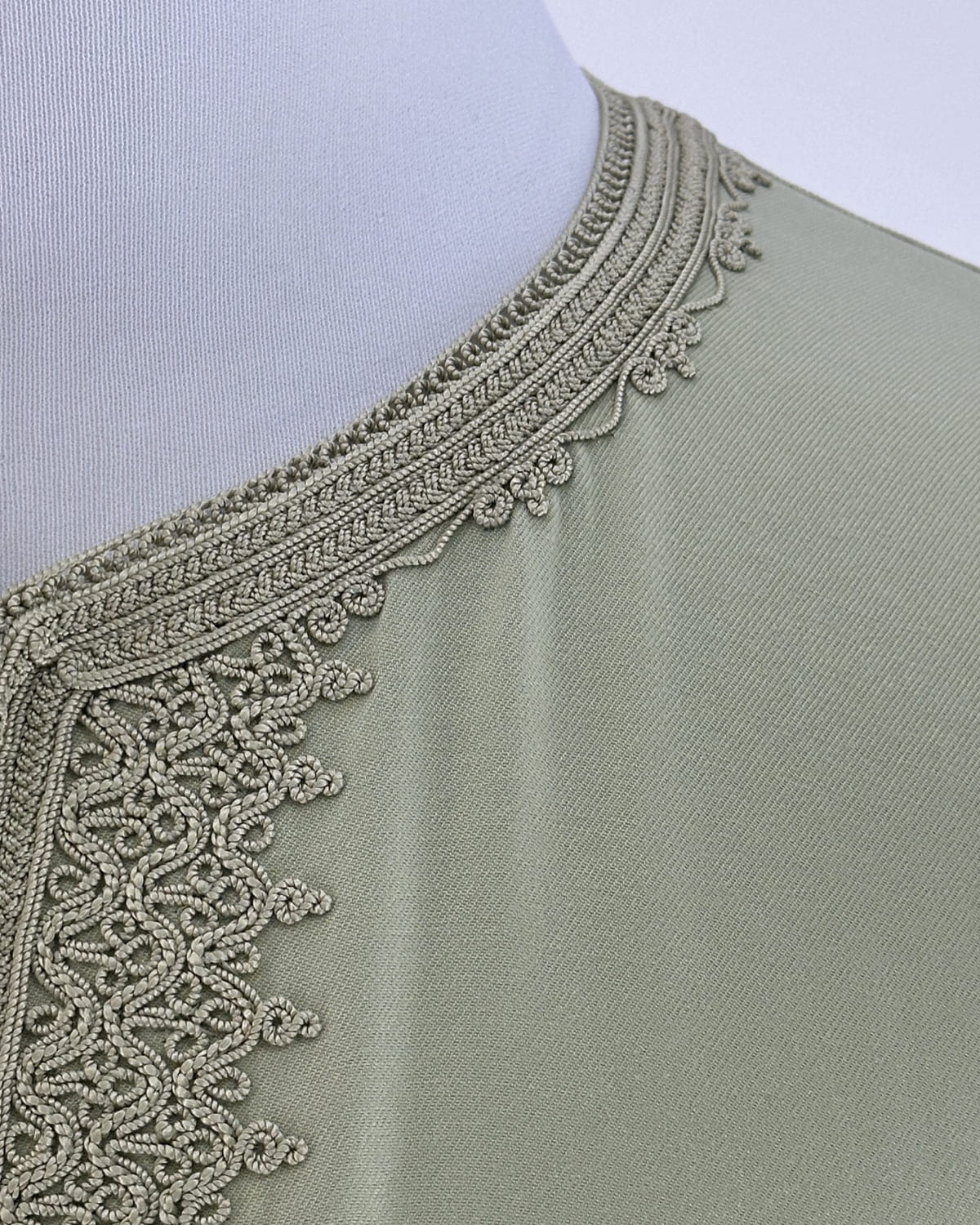 mannequin portant caftan homme matiere gabardine de couleur vert-pastel avec un travail entierement fait main vue details-rapproches