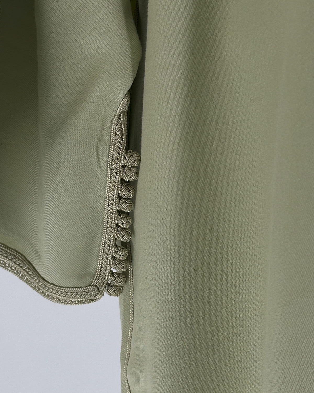 mannequin portant caftan homme matiere gabardine de couleur vert-pastel avec un travail entierement fait main vue manche