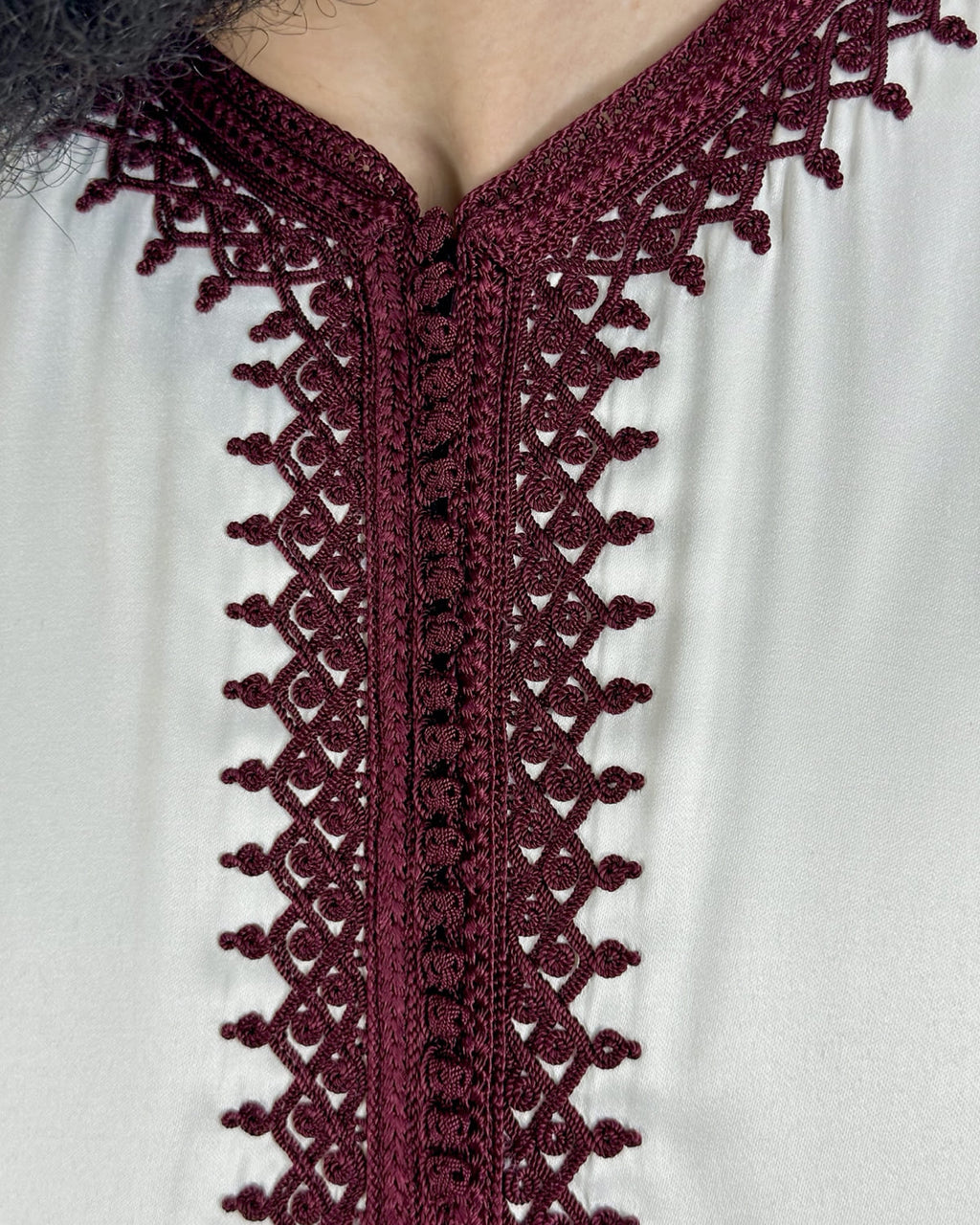 mannequin portant caftan homme matiere mlifa de couleur blanc-et-rouge avec un travail finition faite main vue motifs