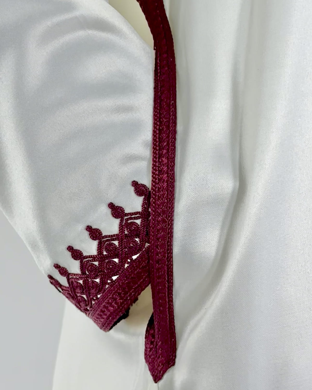 mannequin portant caftan homme matiere mlifa de couleur blanc-et-rouge avec un travail finition faite main vue manche