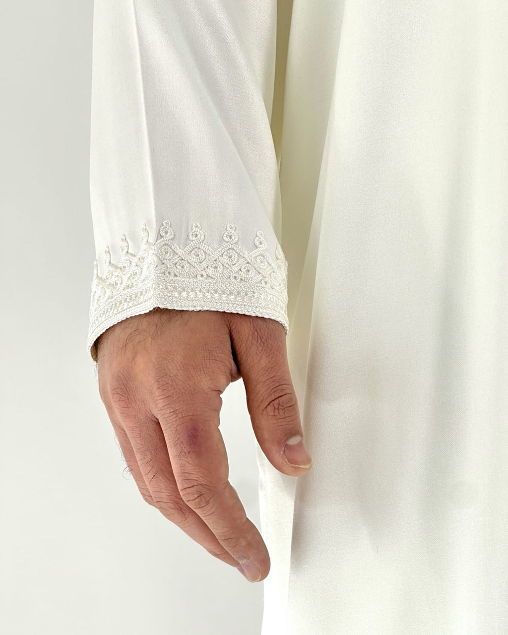 mannequin portant caftan homme matiere mlifa de couleur blanc avec un travail finition faite main vue manche
