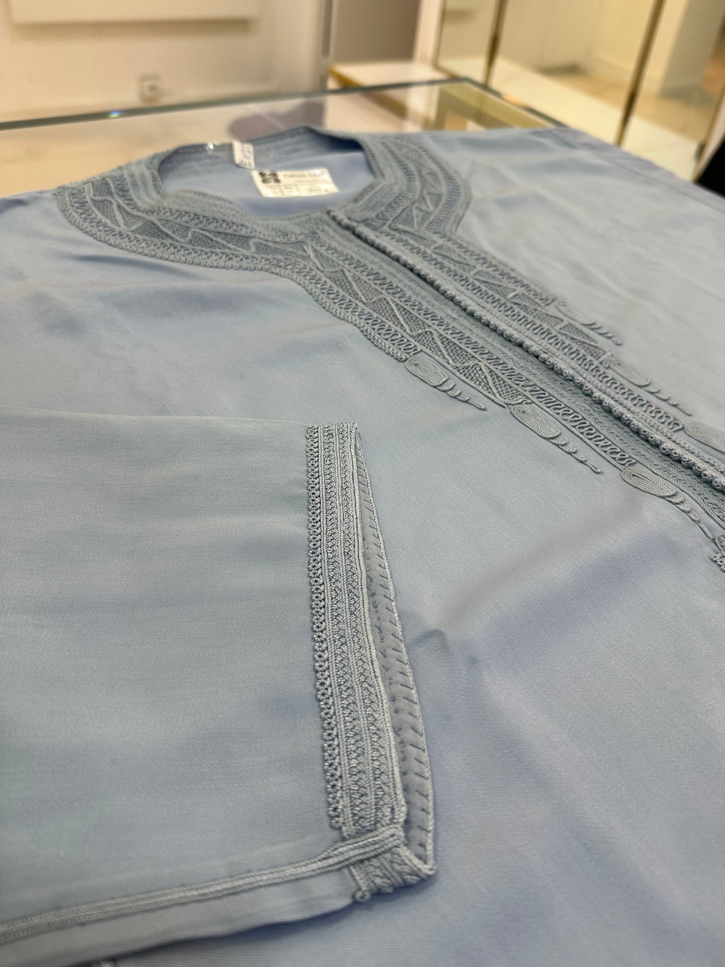 mannequin portant caftan homme matiere mlifa de couleur bleu-ciel avec un travail entierement fait main vue motifs