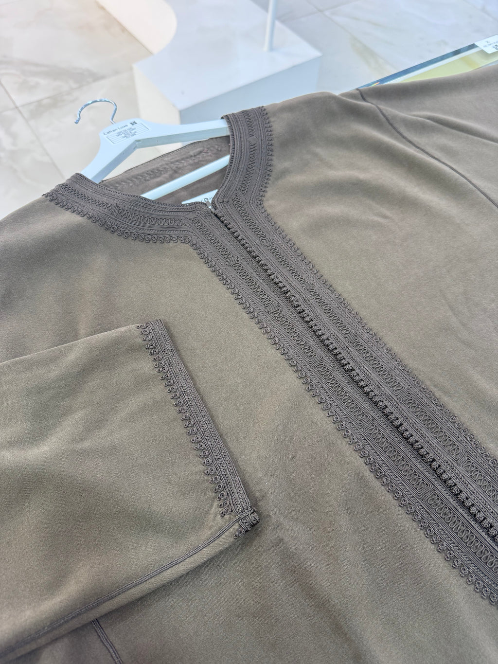 mannequin portant caftan homme matiere mlifa de couleur taupe avec un travail entierement fait main vue motifs