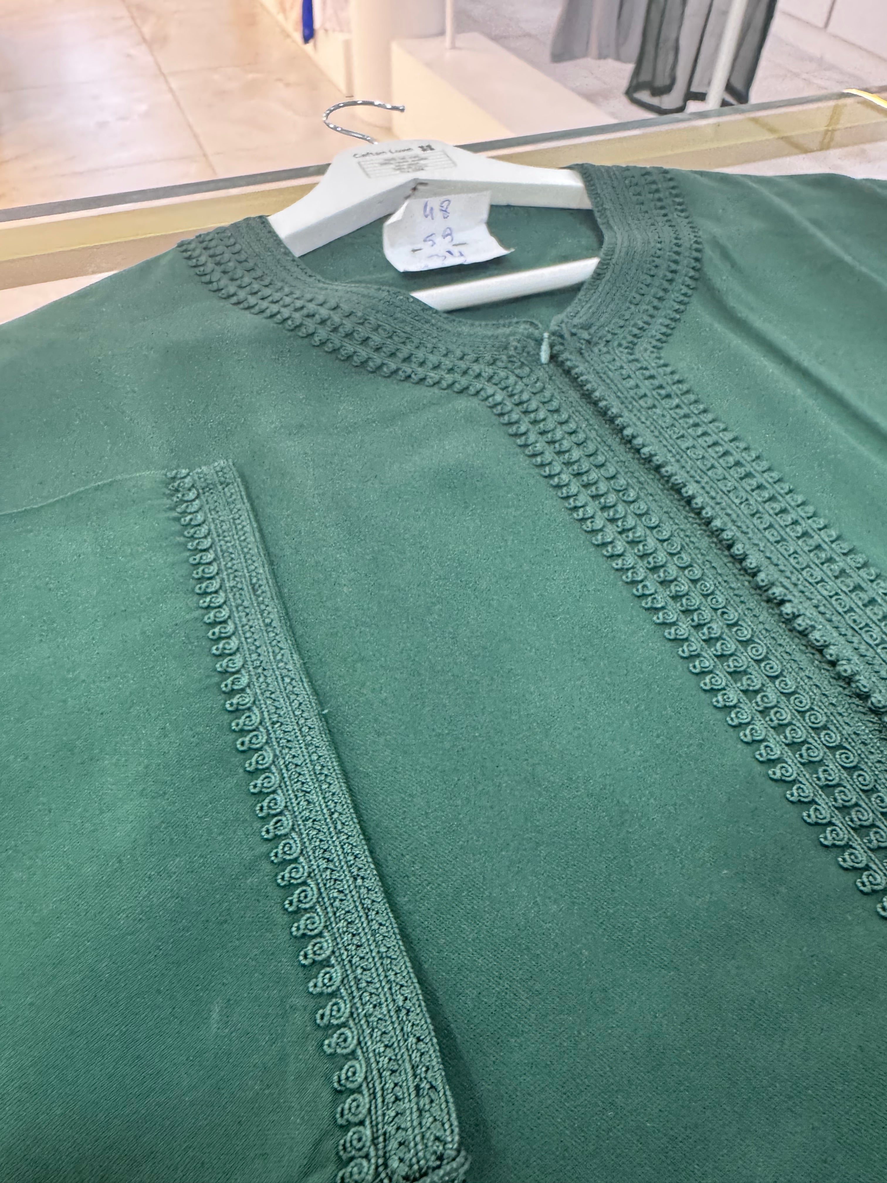 mannequin portant caftan homme matiere mlifa de couleur vert avec un travail entierement fait main vue motifs