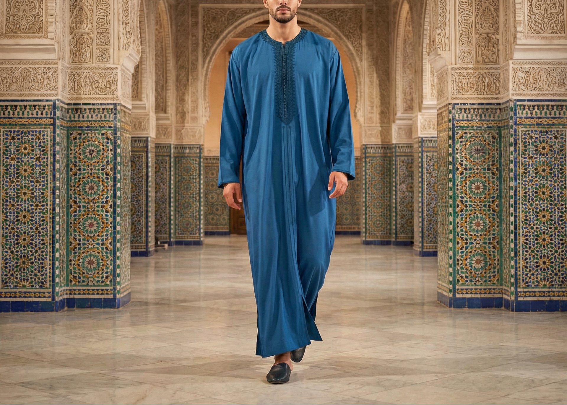 mannequin homme defilant avec un caftan  premium bleu dans un lieu à l'architecture marocaine
