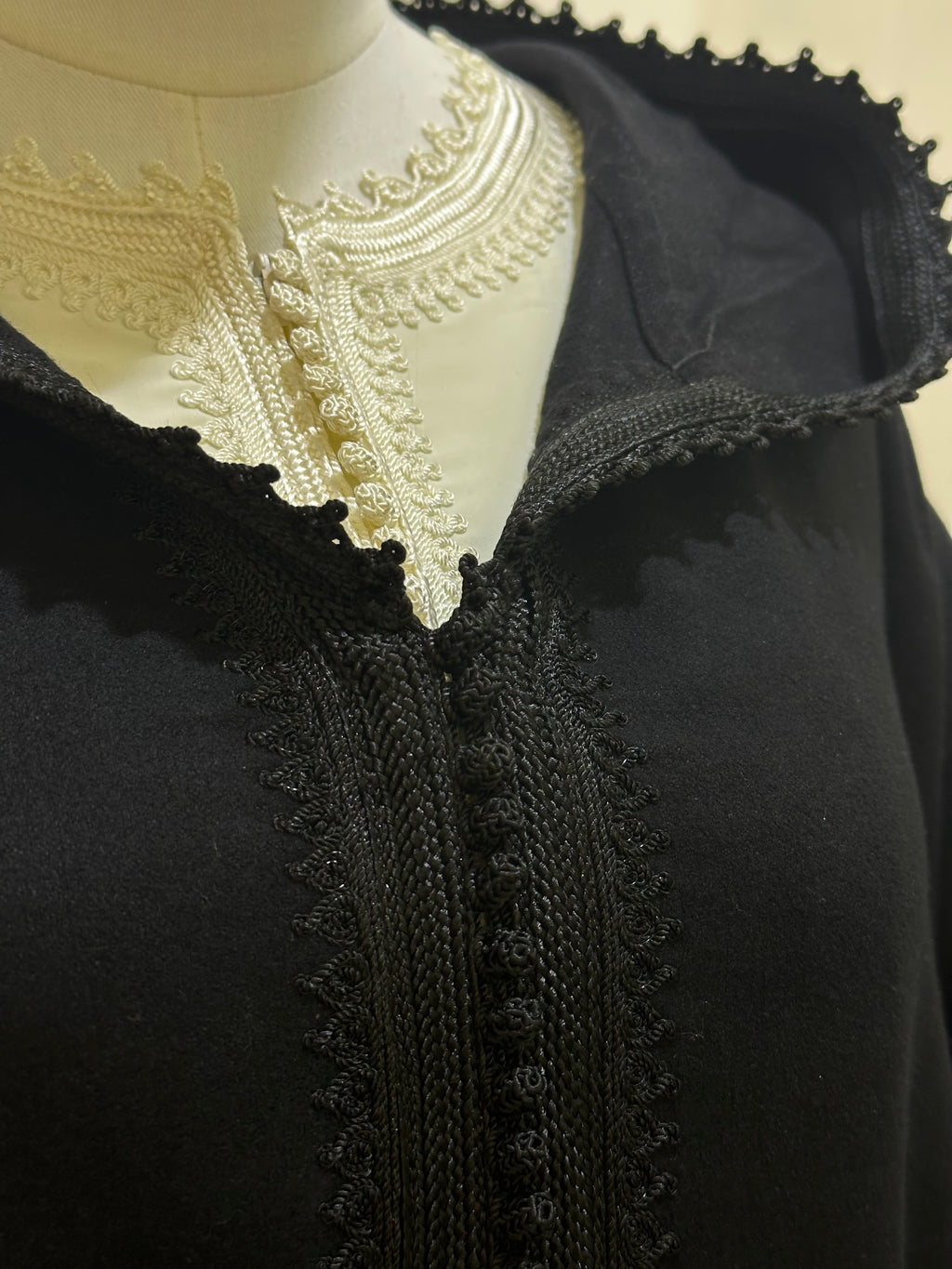 mannequin portant djellaba femme matiere epaisse de couleur noir avec un travail finition faite main vue motifs