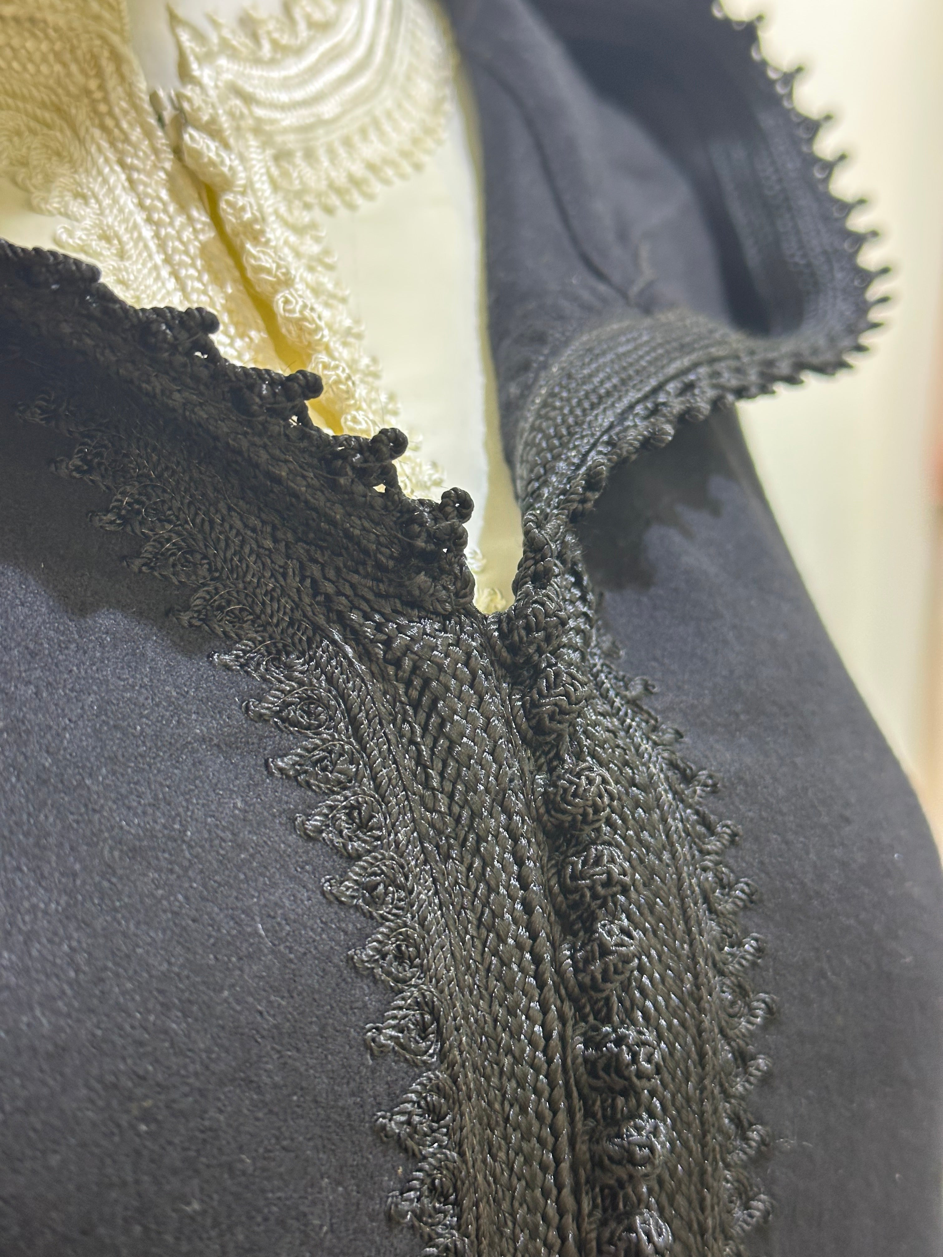 mannequin portant djellaba femme matiere epaisse de couleur noir avec un travail finition faite main vue motifs