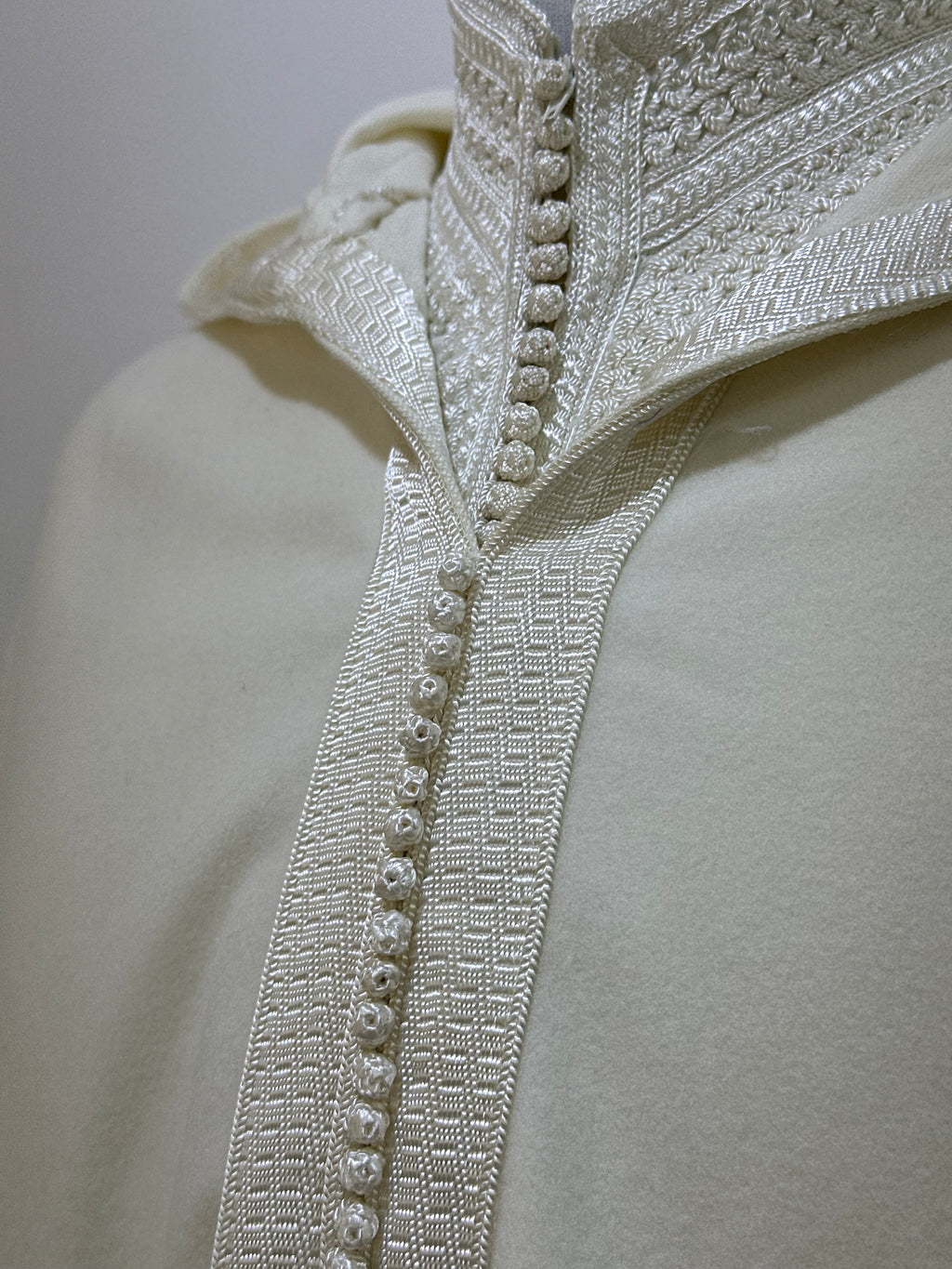 mannequin portant djellaba homme matiere epaisse de couleur blanc avec un travail finition faite main vue motifs