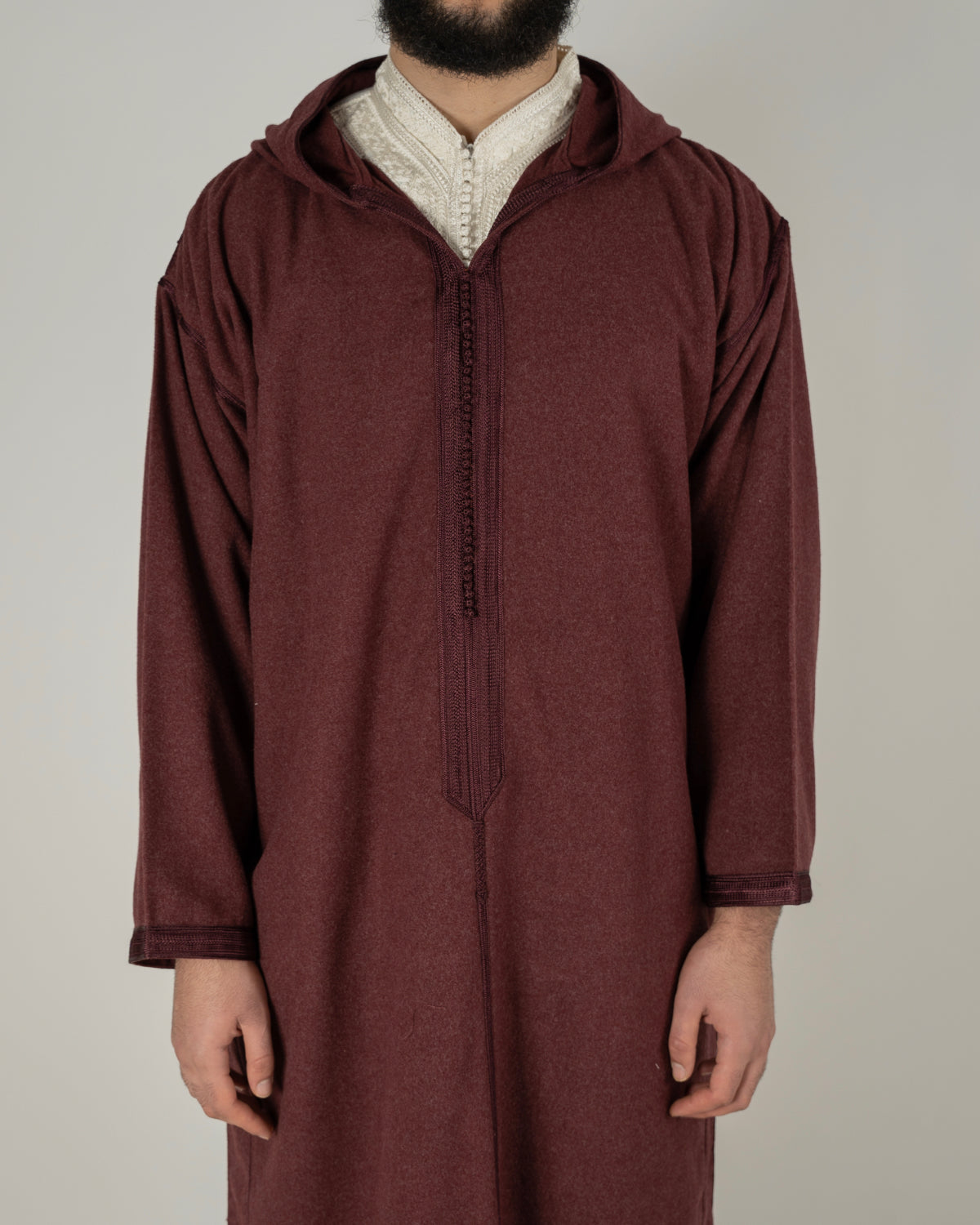mannequin portant djellaba homme matiere epaisse de couleur bordeaux avec un travail finition faite main vue face-rapprochee