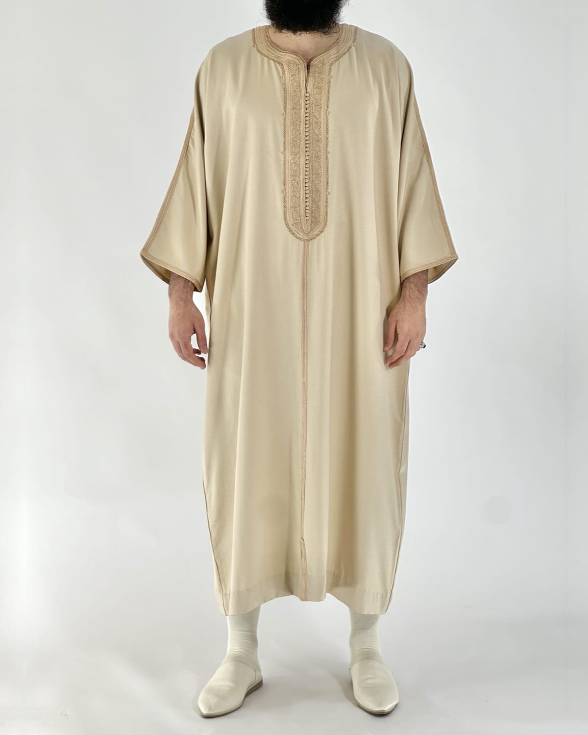 mannequin portant gandoura homme matiere gabardine de couleur beige avec un travail motifs fait main vue entiere