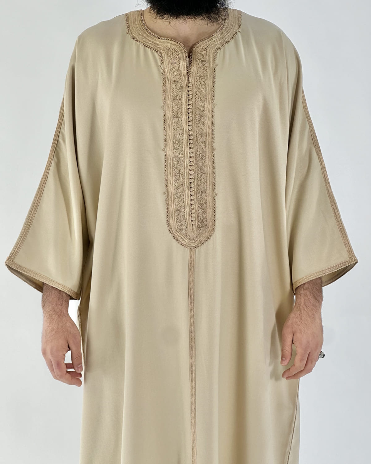 mannequin portant gandoura homme matiere gabardine de couleur beige avec un travail motifs fait main vue face-rapprochee