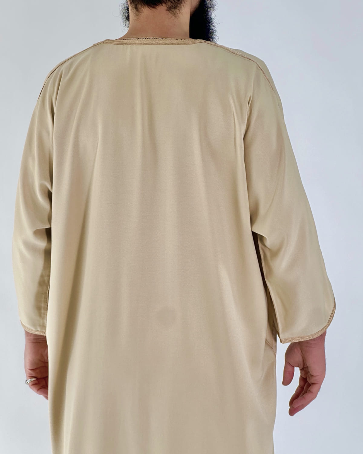 mannequin portant gandoura homme matiere gabardine de couleur beige avec un travail motifs fait main vue dos