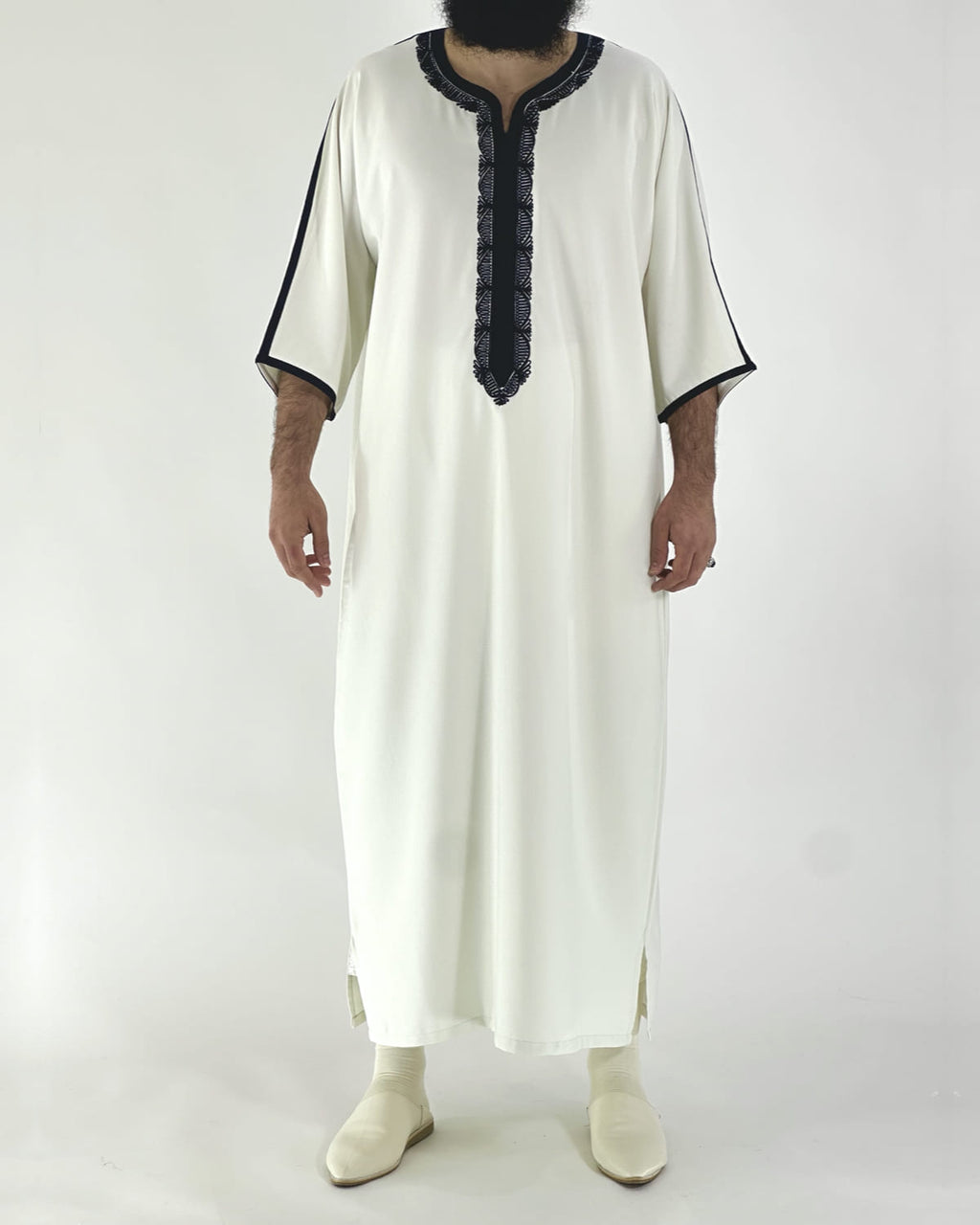 mannequin portant gandoura homme matiere gabardine de couleur blanc-et-bleu avec un travail motifs traditionnels brodés vue entiere