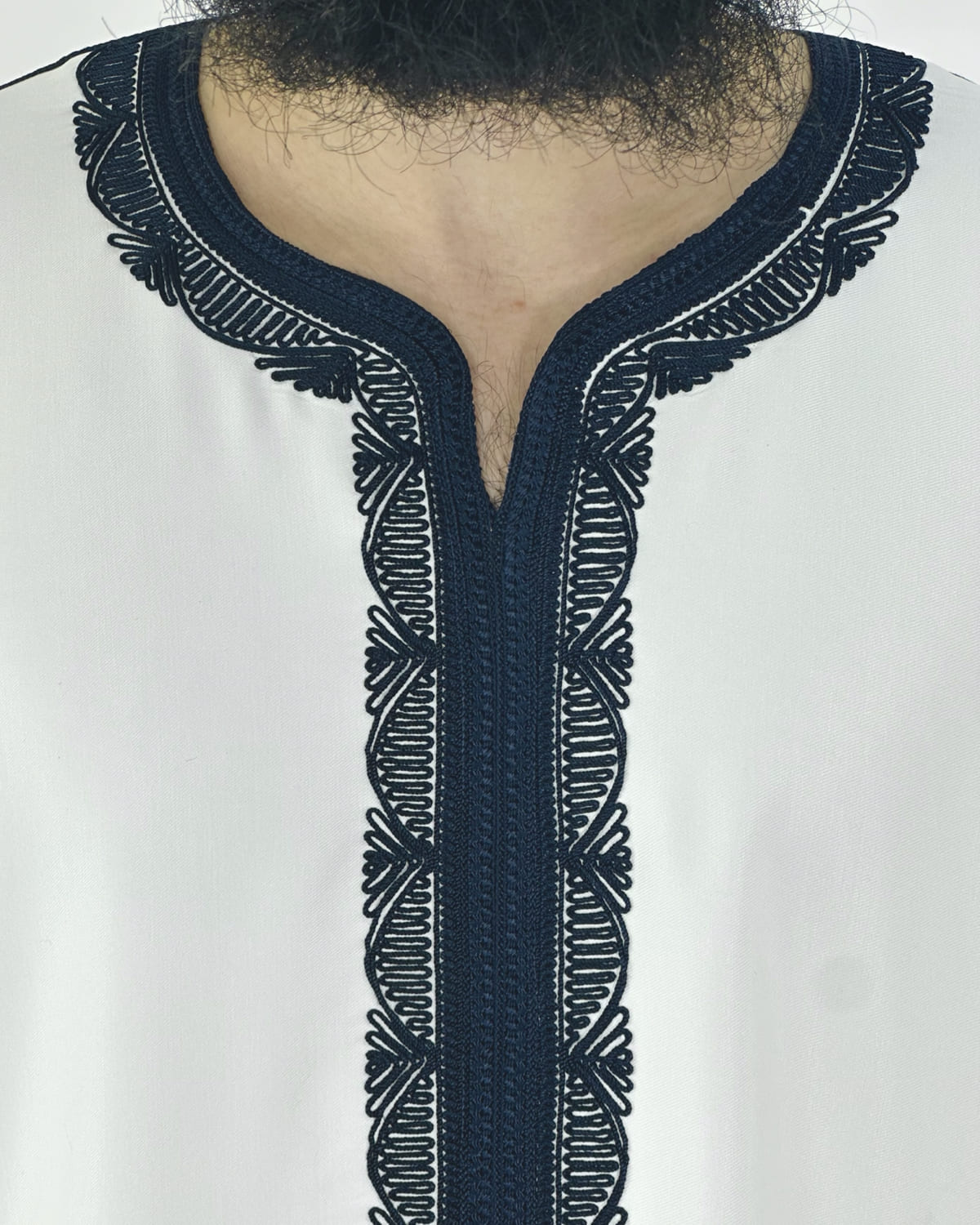 mannequin portant gandoura homme matiere gabardine de couleur blanc-et-bleu avec un travail motifs traditionnels brodés vue motifs