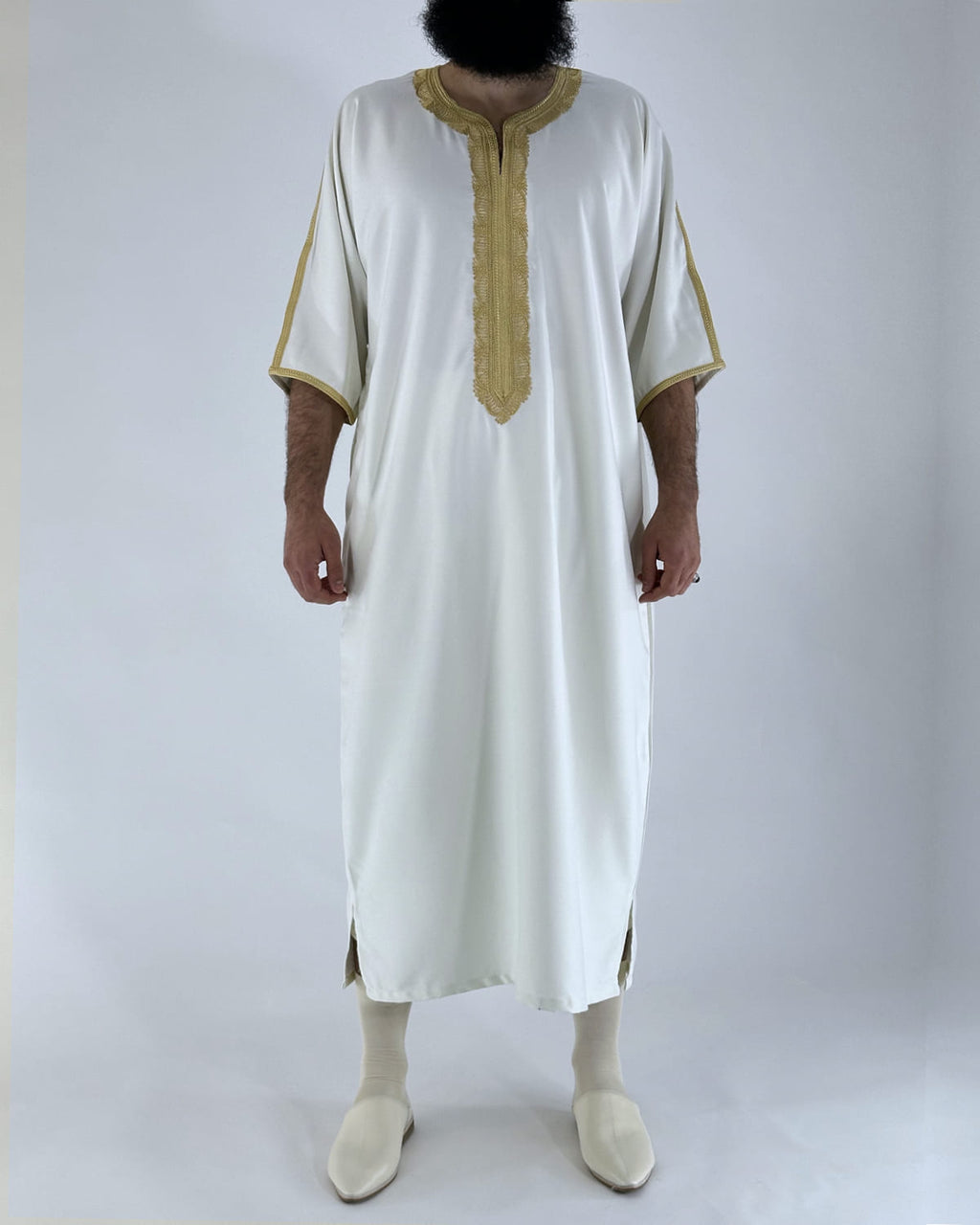 mannequin portant gandoura homme matiere gabardine de couleur blanc-et-or avec un travail motifs traditionnels brodés vue entiere