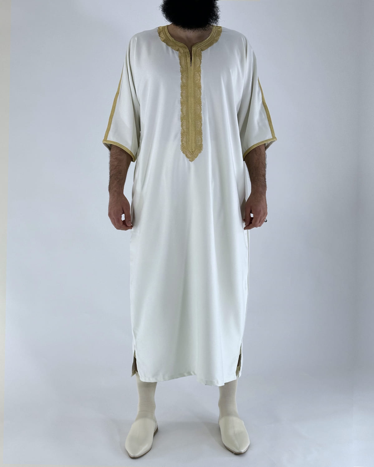 mannequin portant gandoura homme matiere gabardine de couleur blanc-et-or avec un travail motifs traditionnels brodés vue entiere