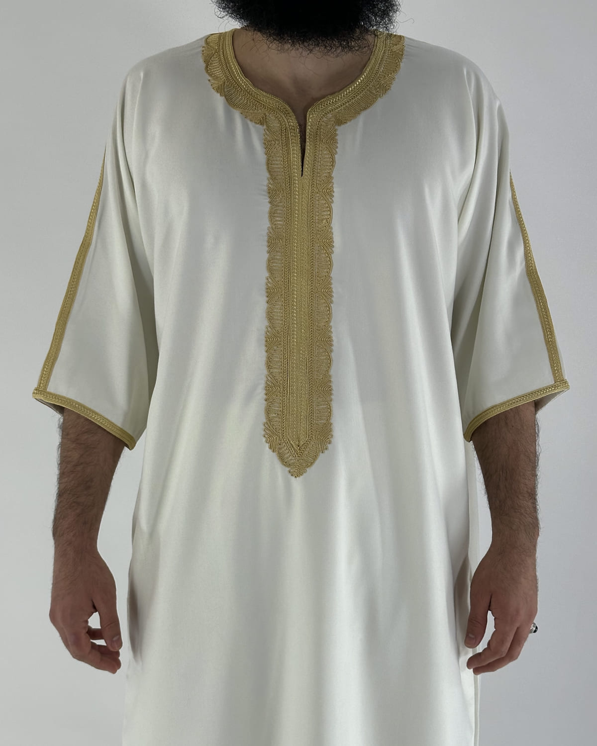 mannequin portant gandoura homme matiere gabardine de couleur blanc-et-or avec un travail motifs traditionnels brodés vue face-rapprochee