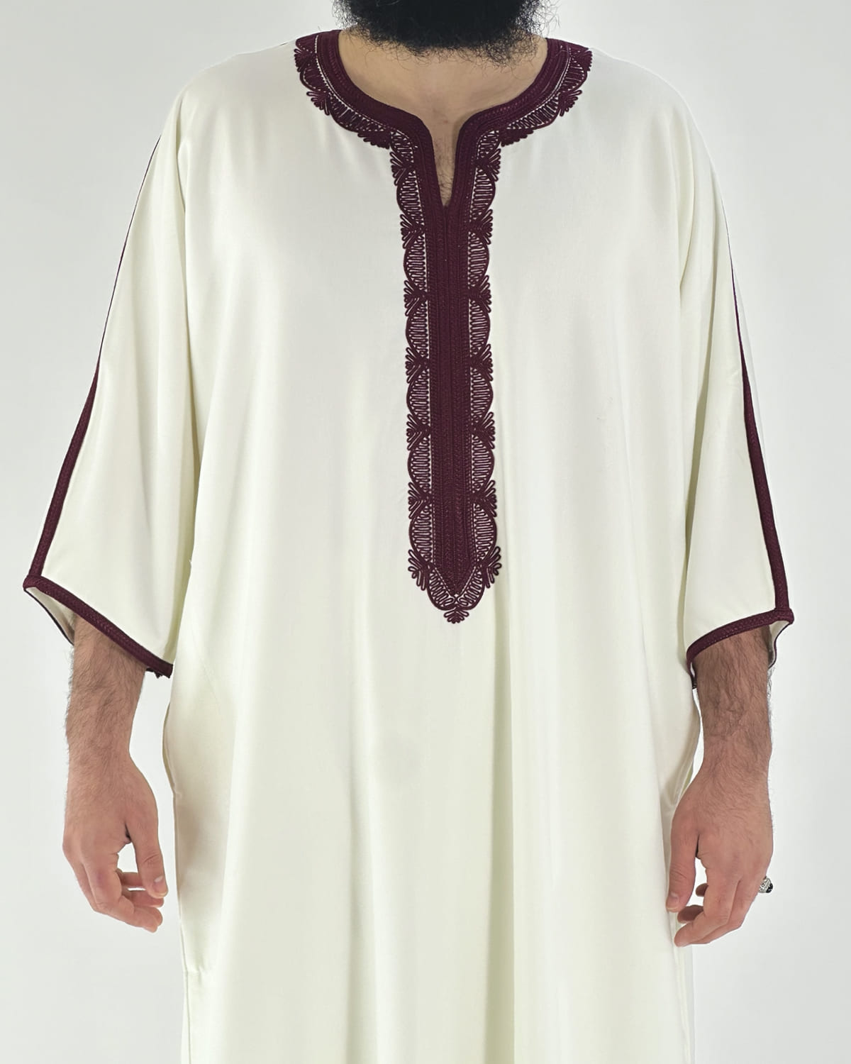 mannequin portant gandoura homme matiere gabardine de couleur blanc-et-rouge avec un travail motifs traditionnels brodés vue face-rapprochee