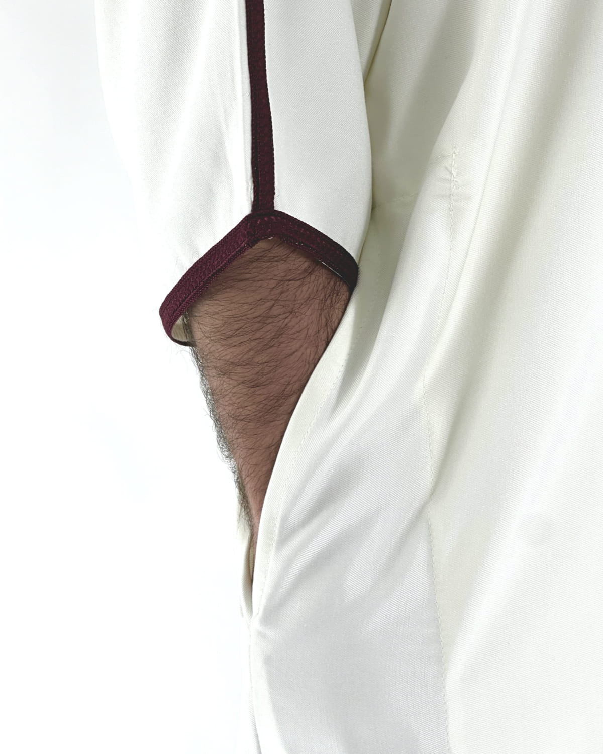 mannequin portant gandoura homme matiere gabardine de couleur blanc-et-rouge avec un travail motifs traditionnels brodés vue manche