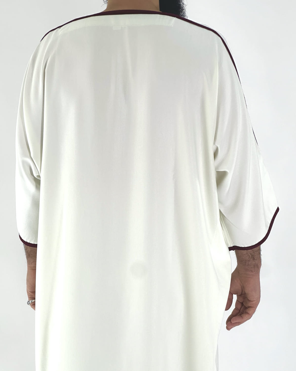 mannequin portant gandoura homme matiere gabardine de couleur blanc-et-rouge avec un travail motifs traditionnels brodés vue dos