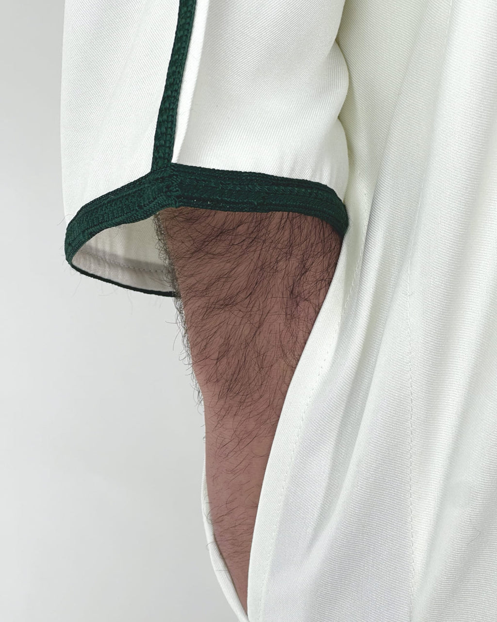 mannequin portant gandoura homme matiere gabardine de couleur blanc-et-vert avec un travail motifs traditionnels brodés vue manche