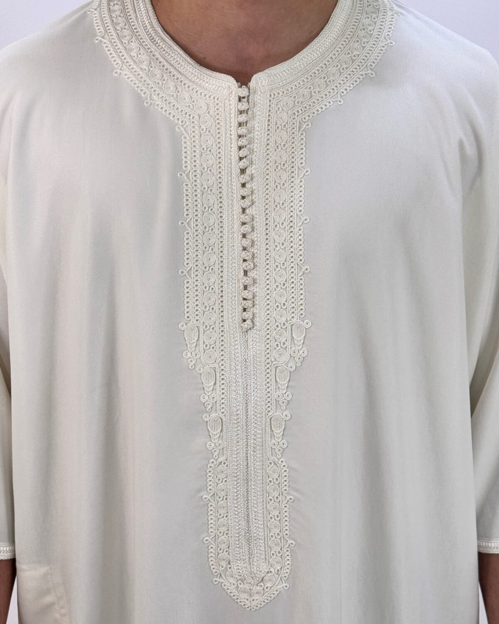mannequin portant gandoura homme matiere gabardine de couleur blanc avec un travail finition faite main vue motifs
