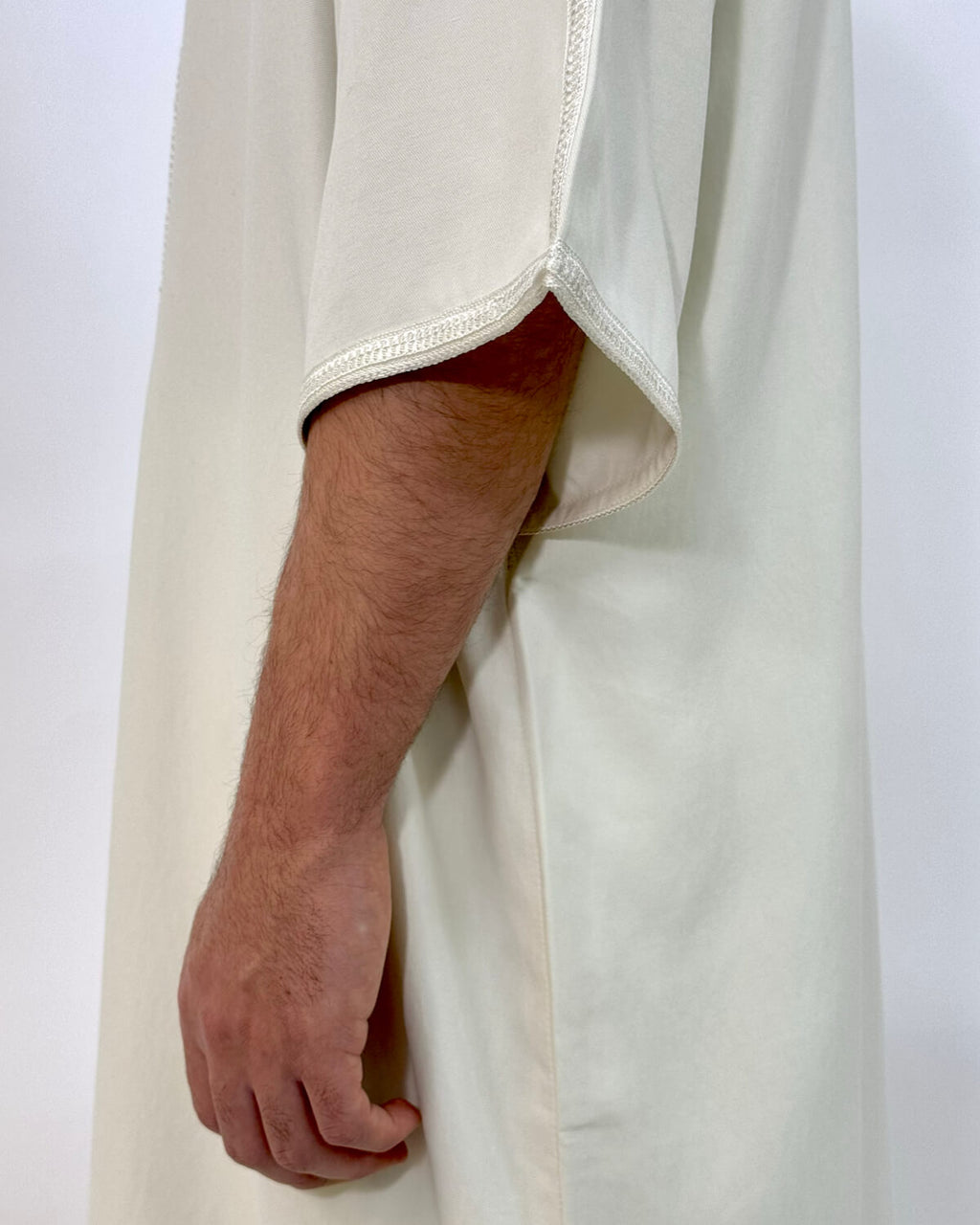 mannequin portant gandoura homme matiere gabardine de couleur blanc avec un travail finition faite main vue manche