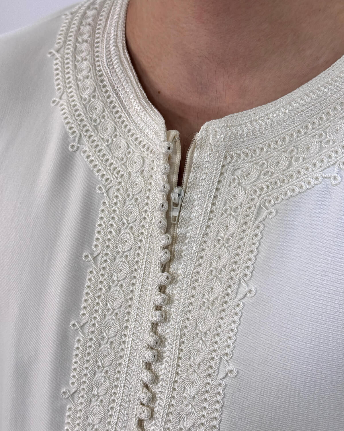 mannequin portant gandoura homme matiere gabardine de couleur blanc avec un travail finition faite main vue details-rapproches