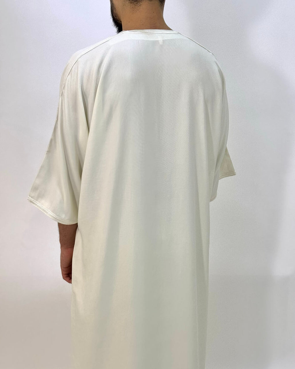 mannequin portant gandoura homme matiere gabardine de couleur blanc avec un travail finition faite main vue dos