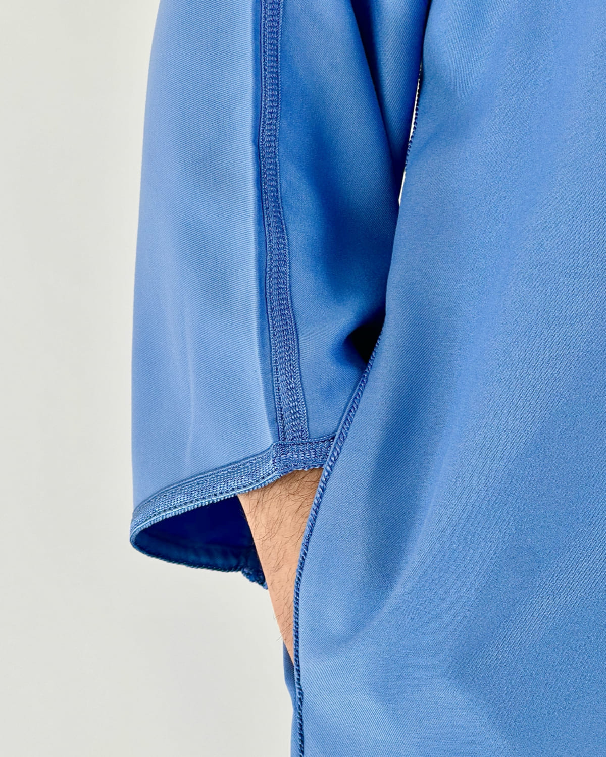 mannequin portant gandoura homme matiere gabardine de couleur bleu avec un travail motifs fait main vue manche