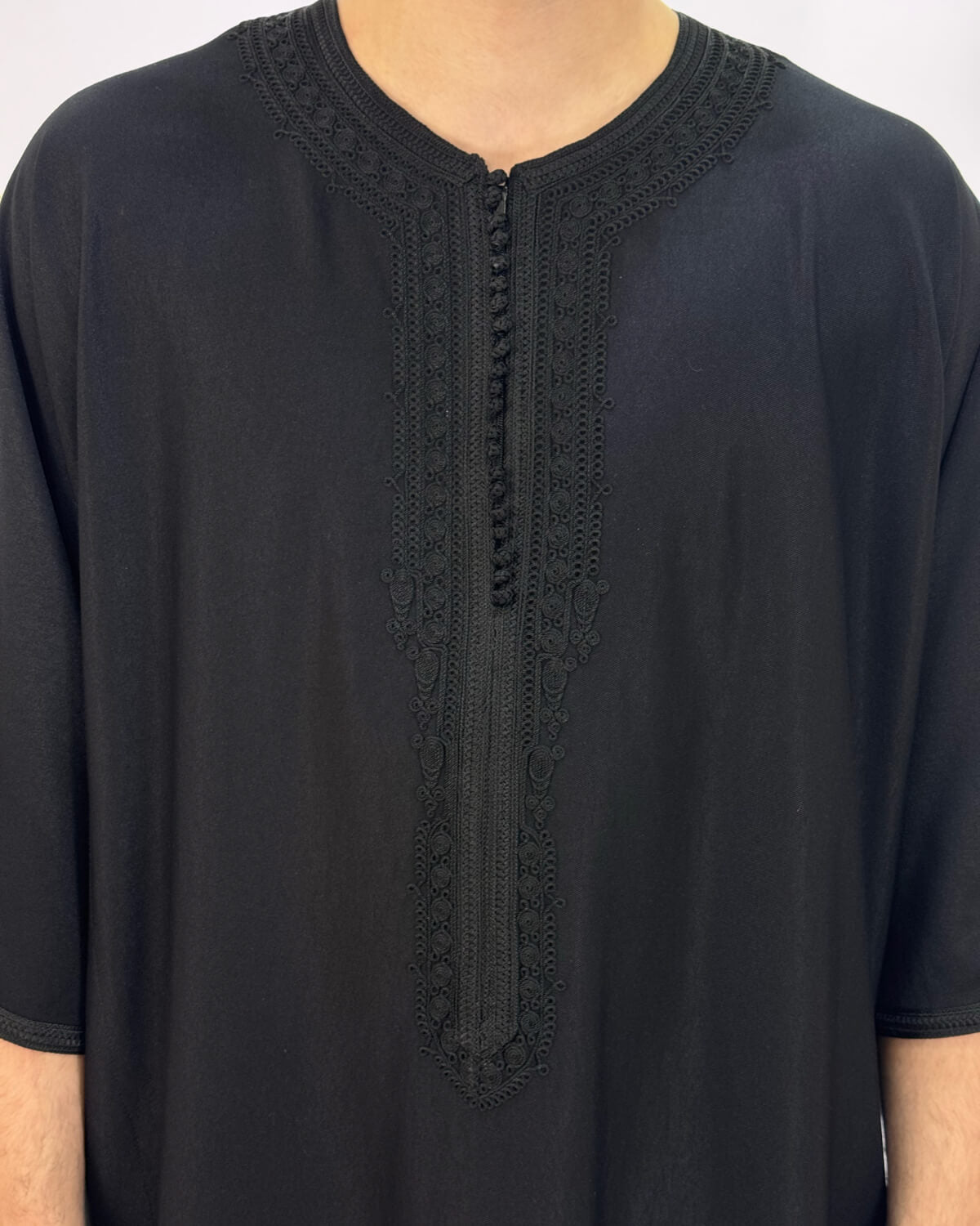 mannequin portant gandoura homme matiere gabardine de couleur noir avec un travail finition faite main vue motifs