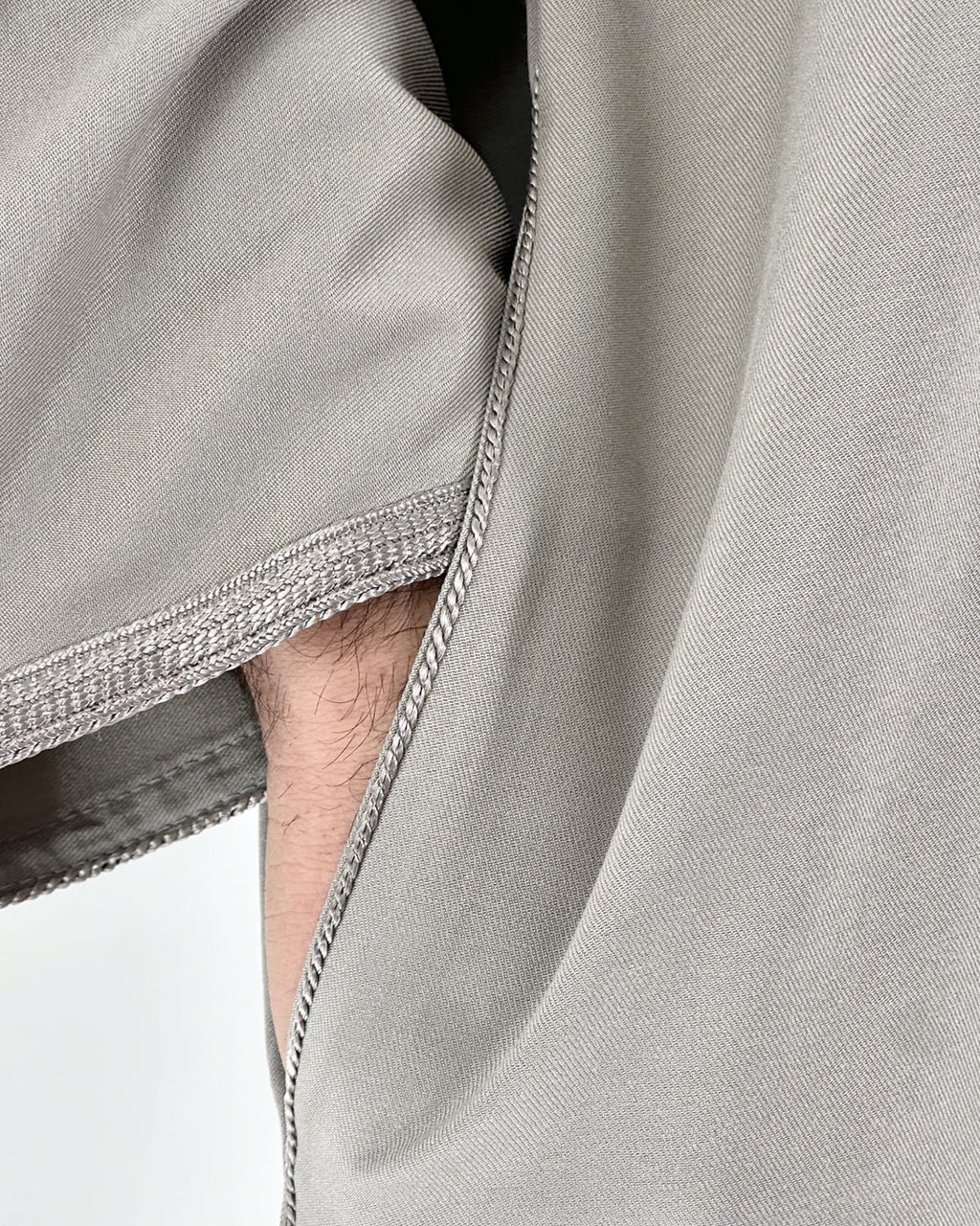 mannequin portant gandoura homme matiere gabardine de couleur taupe avec un travail motifs fait main vue manche
