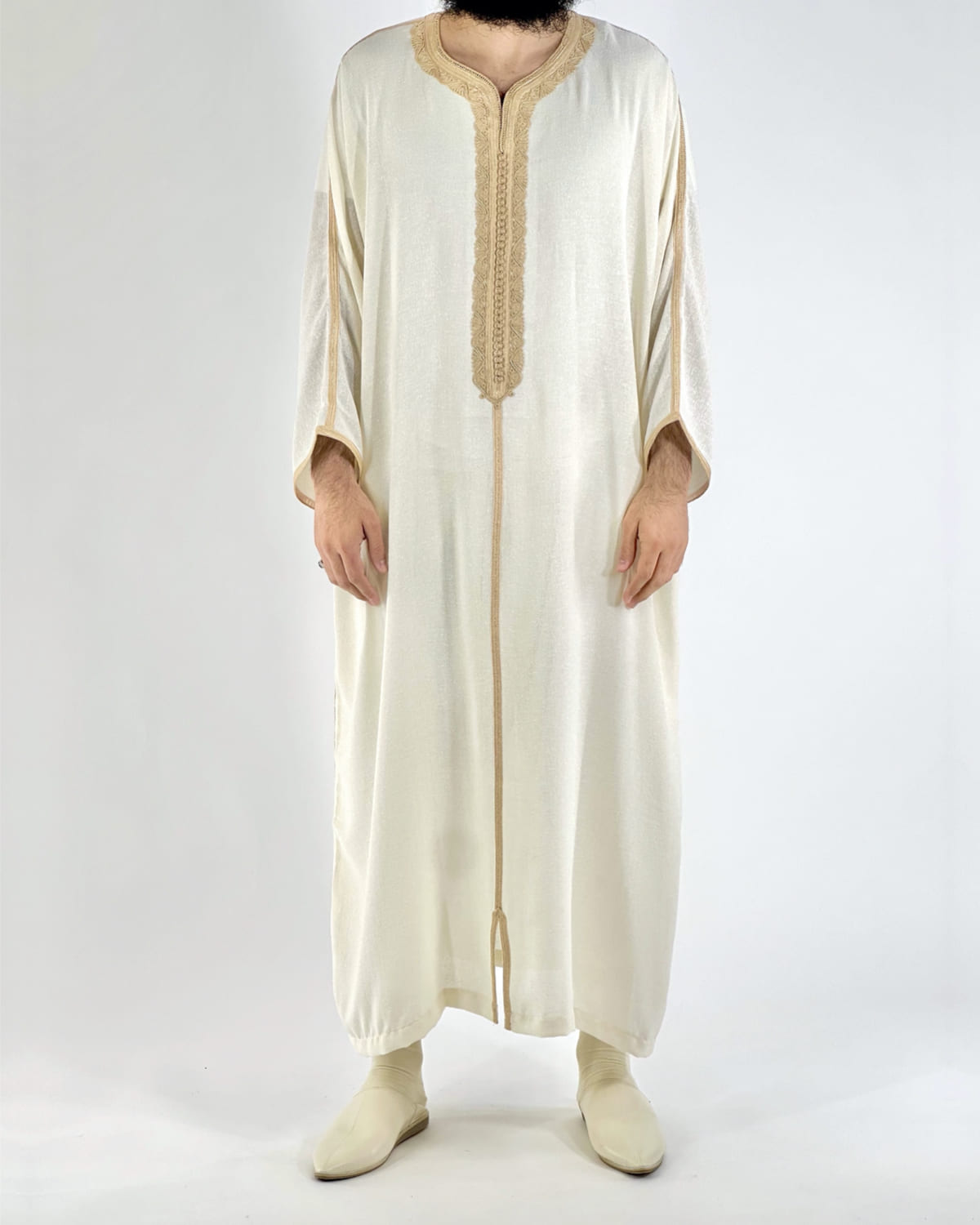 mannequin portant gandoura homme matiere lin de couleur beige avec un travail motifs fait main vue entiere