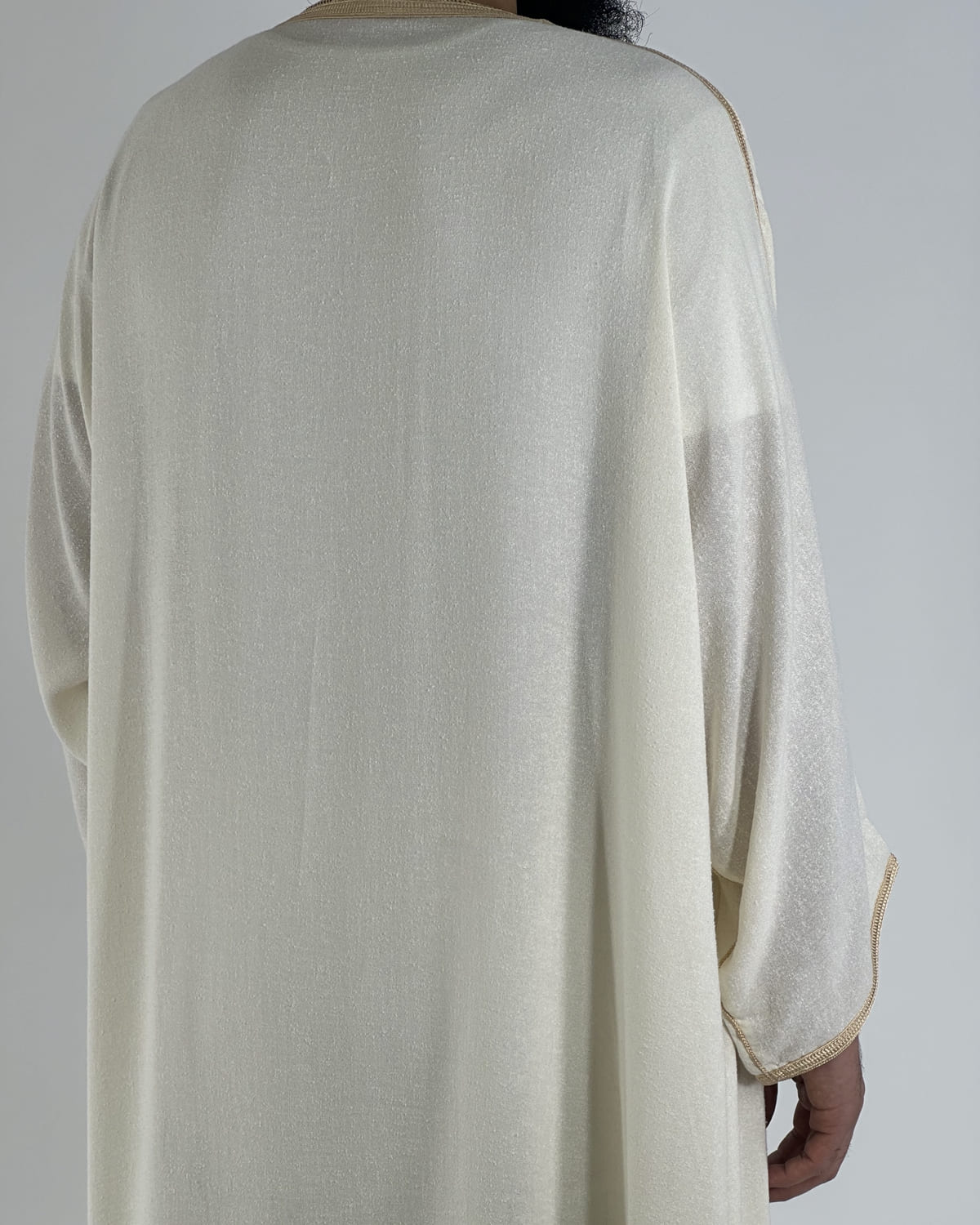 mannequin portant gandoura homme matiere lin de couleur beige avec un travail motifs fait main vue dos