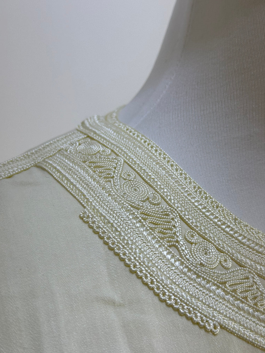 mannequin portant gandoura homme matiere mlifa de couleur blanc avec un travail motifs fait main vue details-col
